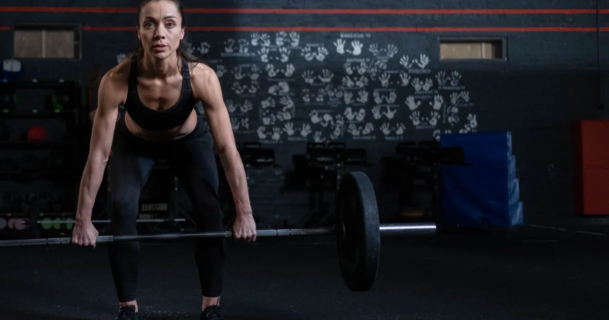 Athlete performing a cable pull through with a rope attachment in a gym