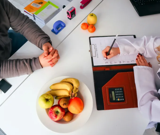 A calculator and bodybuilding foods on a table