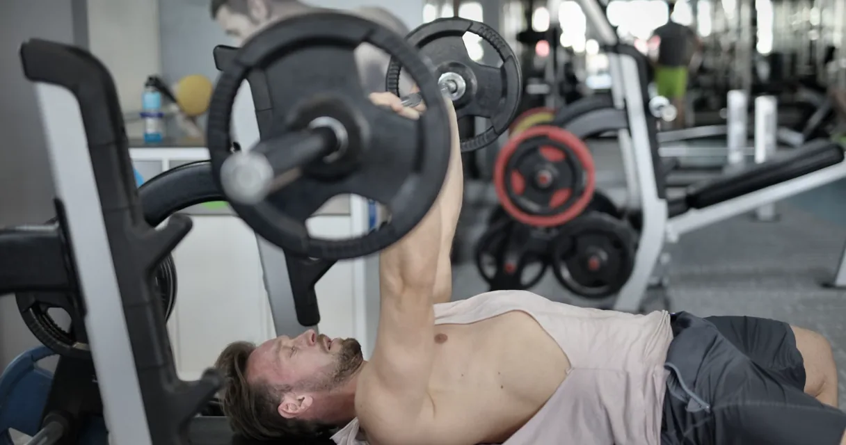 Lifter preparing a shoulder width barbell bench press in a gym